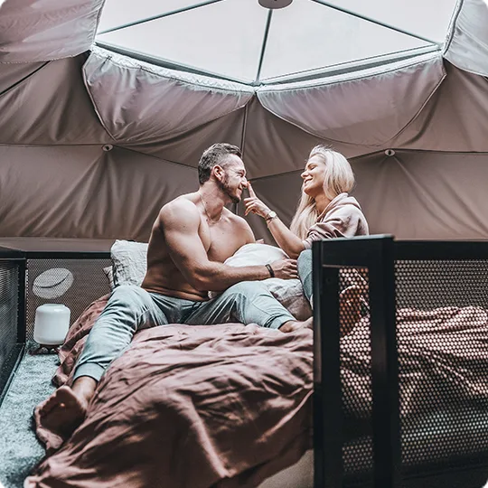 kobieta i mężczyzna na antresoli w namiocie glampingowym